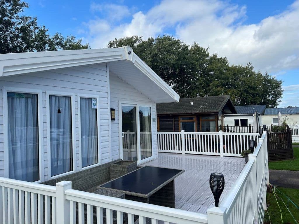 Clean white park home and lodge with decking and railings on a Devon holiday park — Cullompton