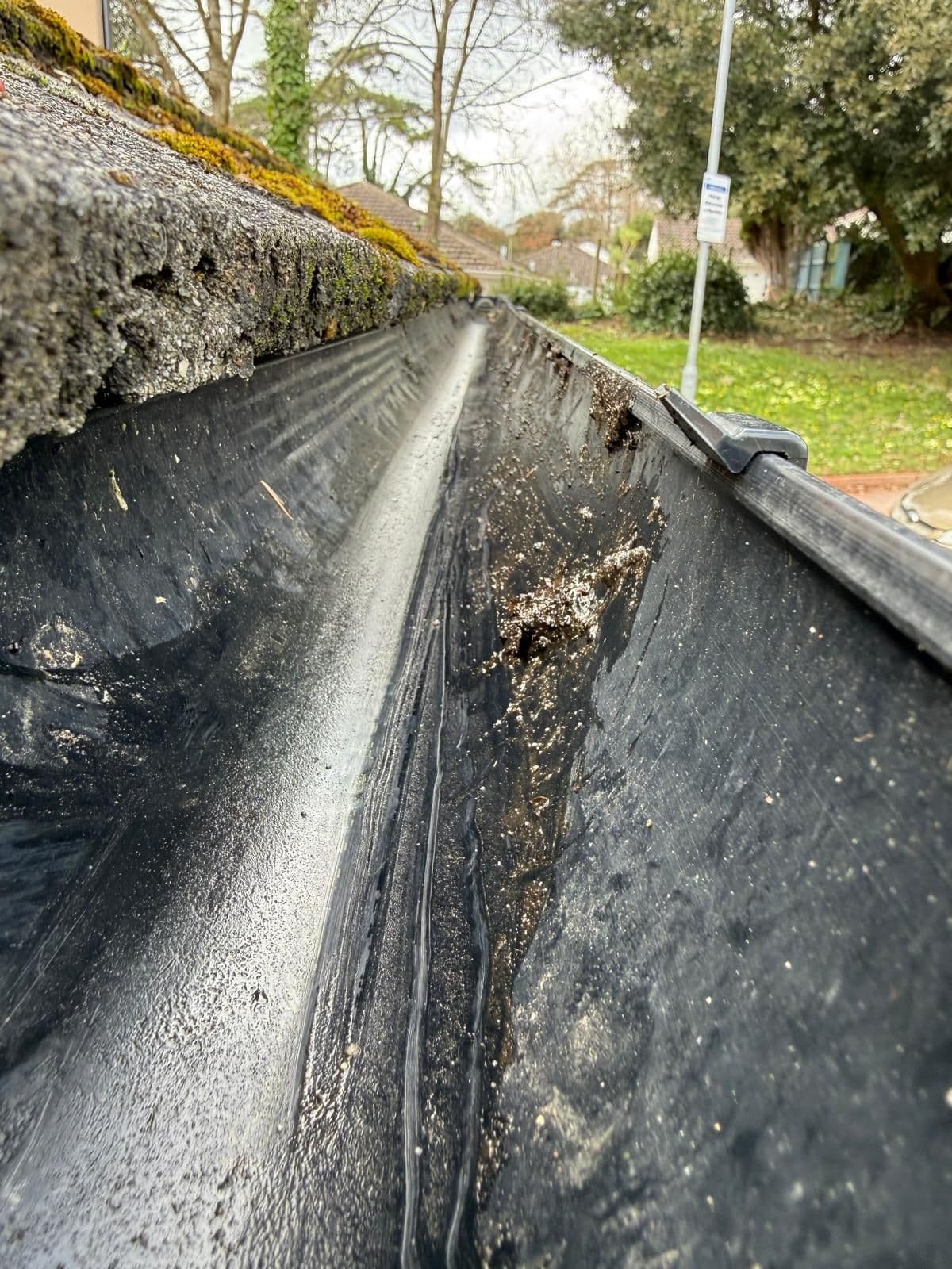 The same gutter run completely cleared to clean black plastic