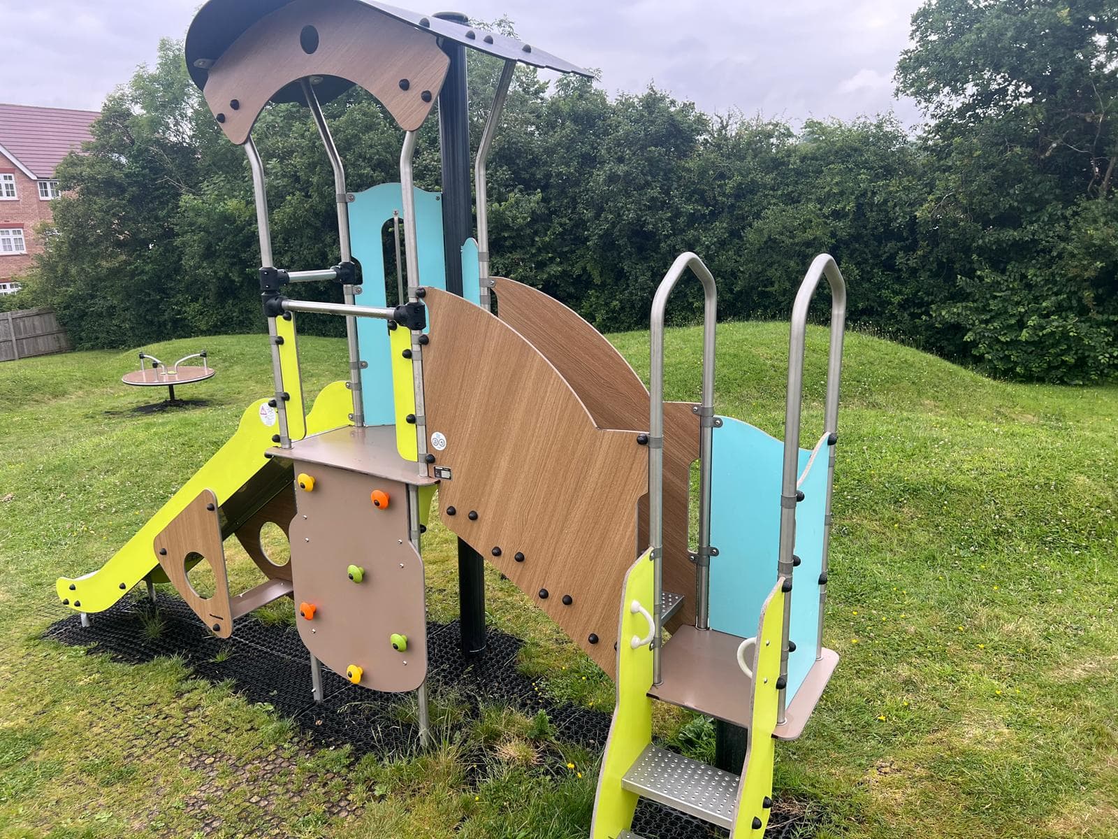 Cleaned children's play-park climbing frame with slide on a grassy area, Devon — Cullompton
