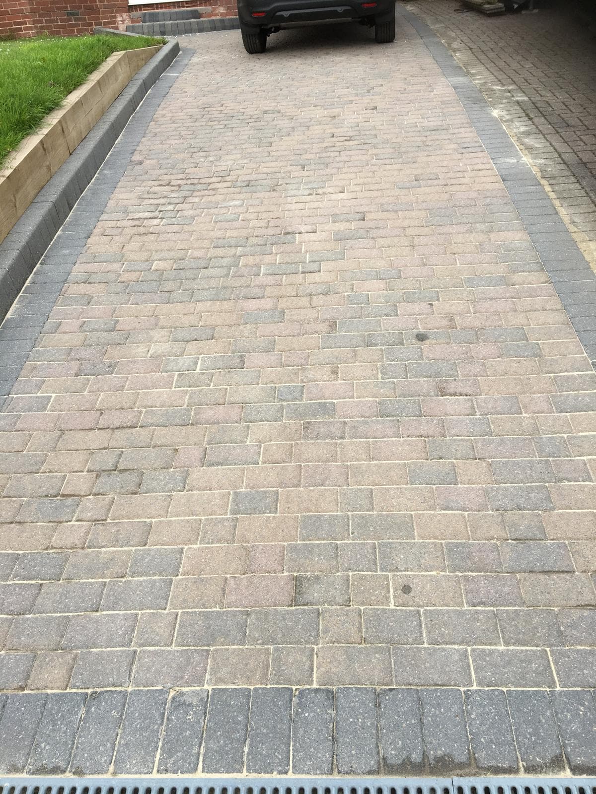 Cleaned block-paved driveway with charcoal border edging after pressure washing, Devon — Cullompton